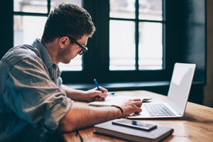 A digital marketer in front of his laptop analysis page content